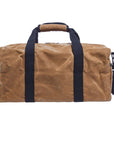 Back of the tan waxed canvas duffel bag with navy webbing handles