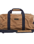 Front of a tan waxed canvas duffel bag with navy webbing handles and a padded shoulder strap, on a white background