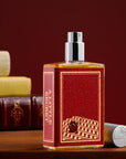 A Little Secret full-size glass bottle with a red label on a wooden table beside old leather-bound books