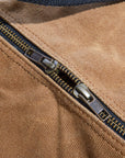 Close-up of the brass zippers on the tan waxed canvas duffel bag