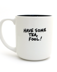 White mug with black interior and text 'HAVE SOME TEA, FOOL!' on a white background