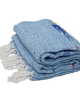 Light blue thunderbird blanket folded with white fringe, on a white background