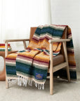 Yellow, maroon and dark green striped falsa blanket draped over a wooden armchair