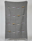 Charcoal wool blanket with rows of colorful woven thunderbirds, hanging flat