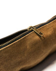 Close-up of the brass zipper pull on a tan waxed canvas bag