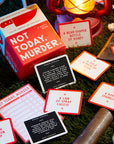 Not Today, Murder game spread out on a table with cards and a lit lamp