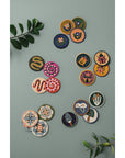 Set of 4 beaded coasters from Danica Studio’s Gardenland collection featuring bold snakes in earthy greens with pops of pink and red. Durable and eye-catching.