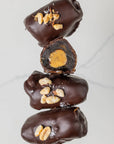 Stack of chocolate-covered treats with a visible filling on a light background