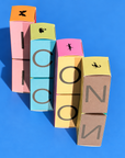 Stacked Icons perfume boxes spelling ICON on a blue background