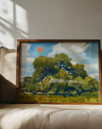 Framed live oak landscape print leaning against a beige sofa in a sunlit room