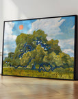 Large black-framed live oak print leaning on a wood floor against a white wall