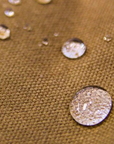 Close-up of water beading on tan waxed canvas