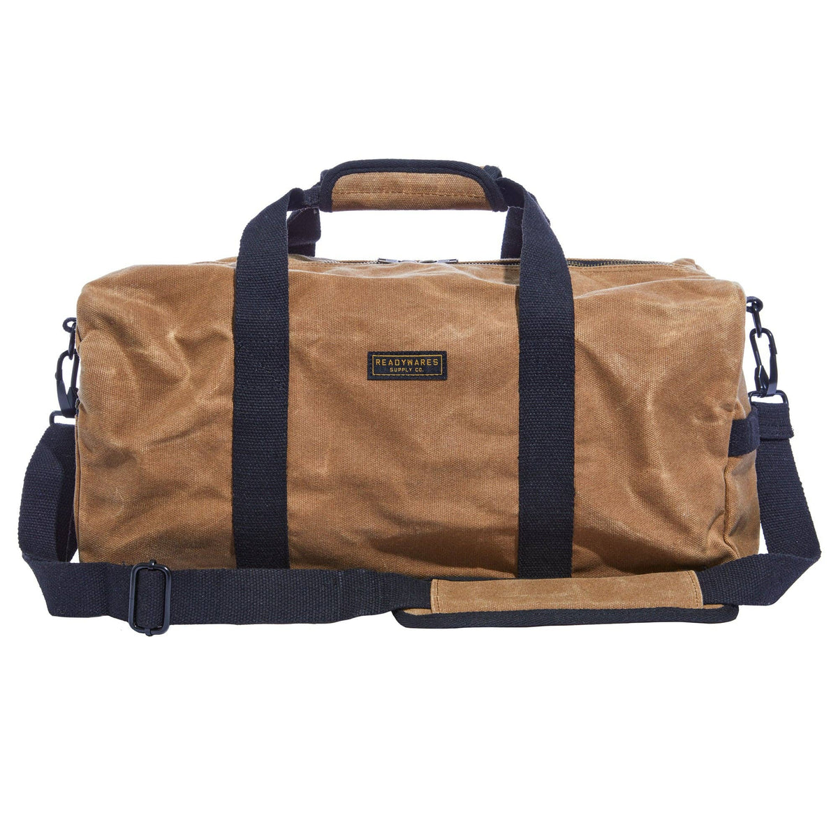 Front of a tan waxed canvas duffel bag with navy webbing handles and a padded shoulder strap, on a white background