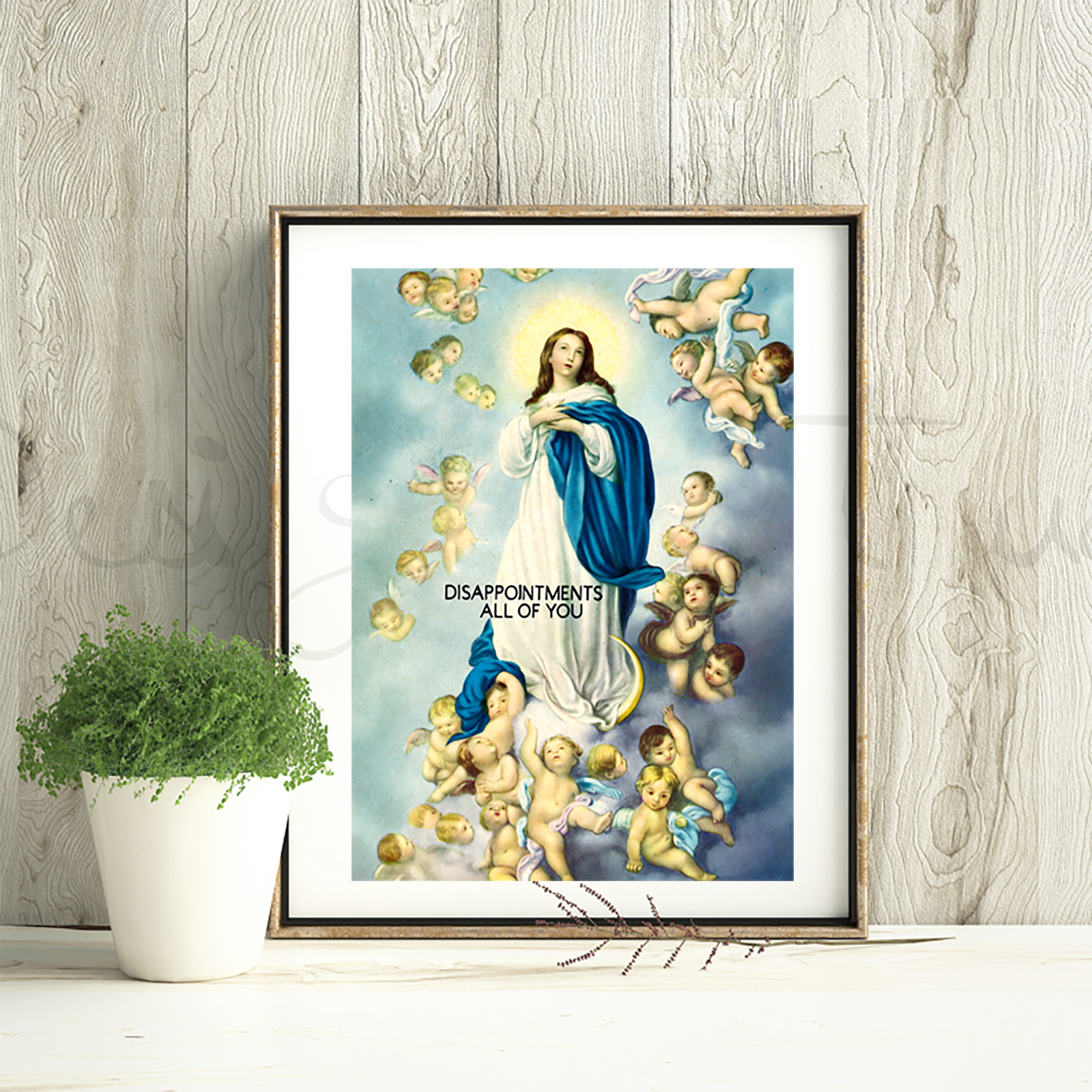 Framed artwork of a religious figure surrounded by cherubs on a wooden wall.