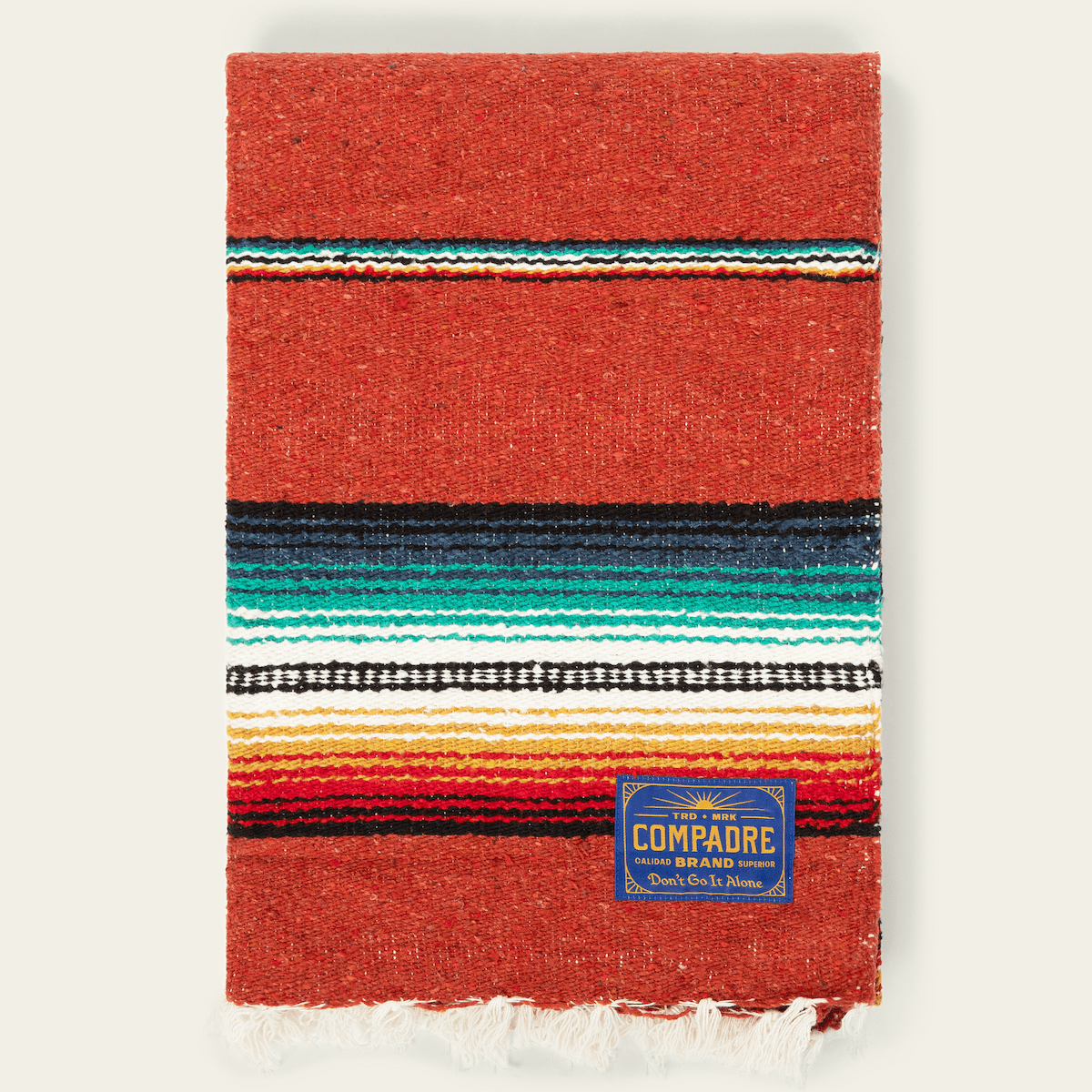 Red-orange sarape blanket with turquoise, black, white and yellow stripes