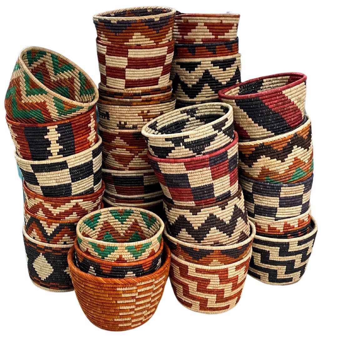 Stack of handwoven baskets in assorted rust, black, cream and green zigzag and checkered patterns