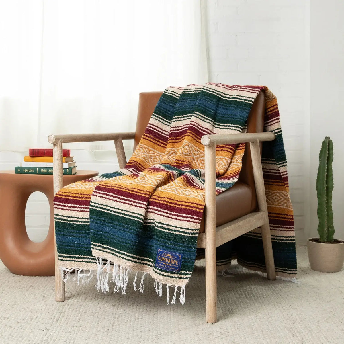 Yellow, maroon and dark green striped falsa blanket draped over a wooden armchair