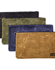 Four waxed canvas zipper tool bags in black, olive, navy and tan, layered on a white background