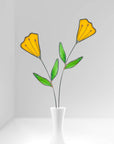 Two stained glass yellow tulip stems in a white bud vase