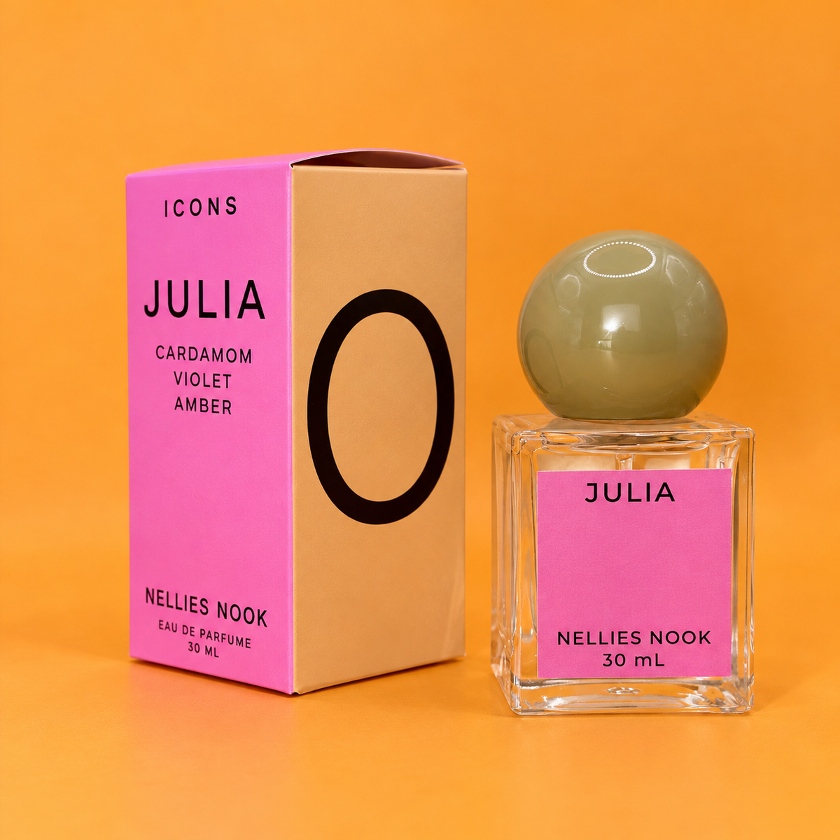 Pink and tan Icons Julia box beside a square glass perfume bottle with a pale green sphere cap, on an orange background