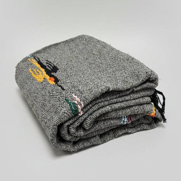 Charcoal wool thunderbird blanket folded on a white background