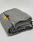 Charcoal wool thunderbird blanket folded on a white background