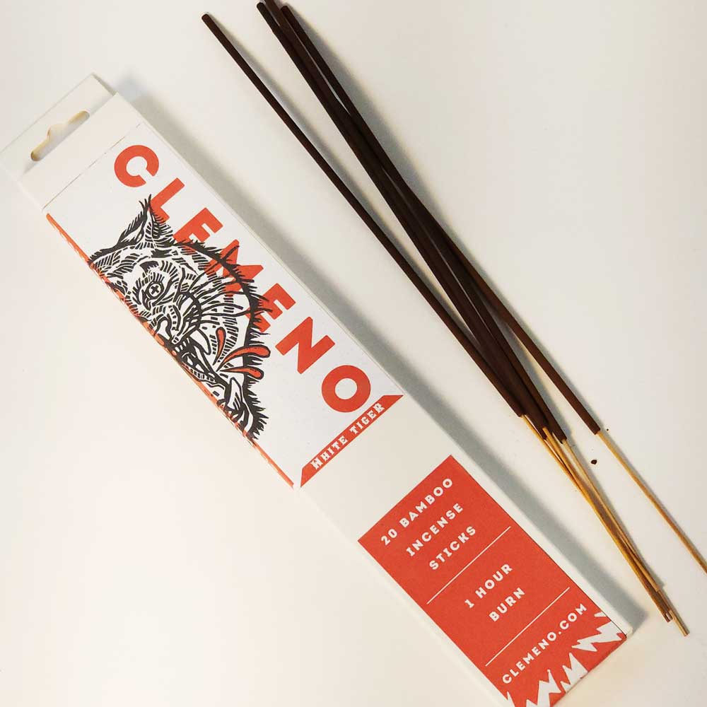 Clemeno White Tiger incense box with a tiger illustration beside dark bamboo incense sticks
