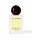 Whitney perfume bottle with a dark burgundy sphere cap and pale yellow label on a white background
