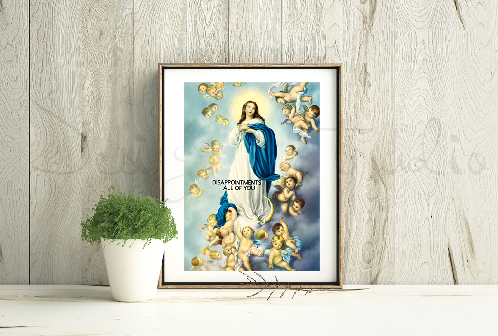 Framed artwork of a religious figure with cherubs on a wooden wall.
