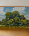 Live oak art print in a wood frame leaning against a white wall on a wood floor