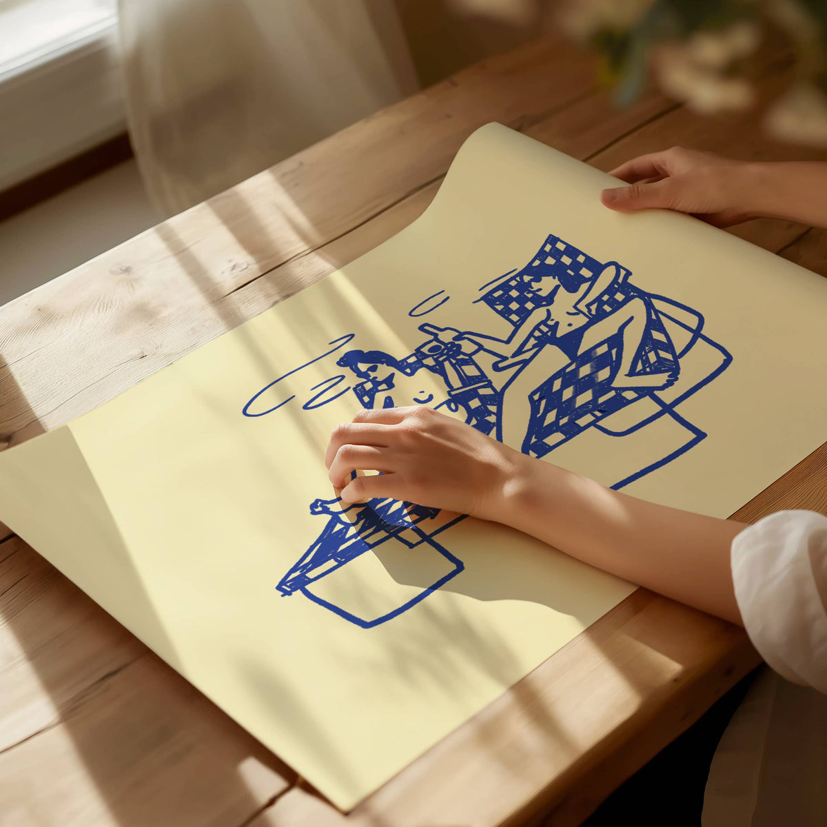 Unframed Swim Club print laid on a table in sunlight with a hand smoothing it flat