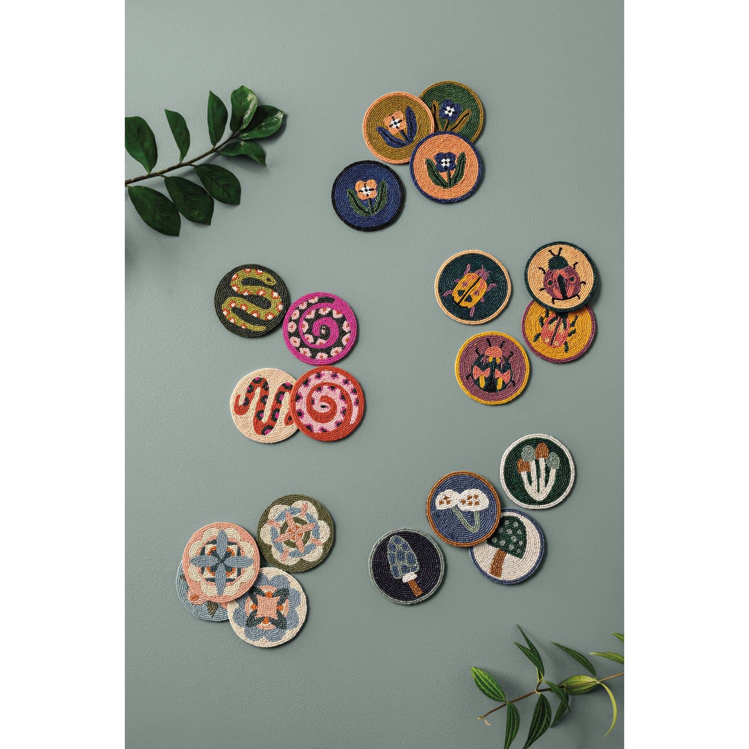 Set of 4 beaded coasters from Danica Studio’s Gardenland collection featuring bold snakes in earthy greens with pops of pink and red. Durable and eye-catching.
