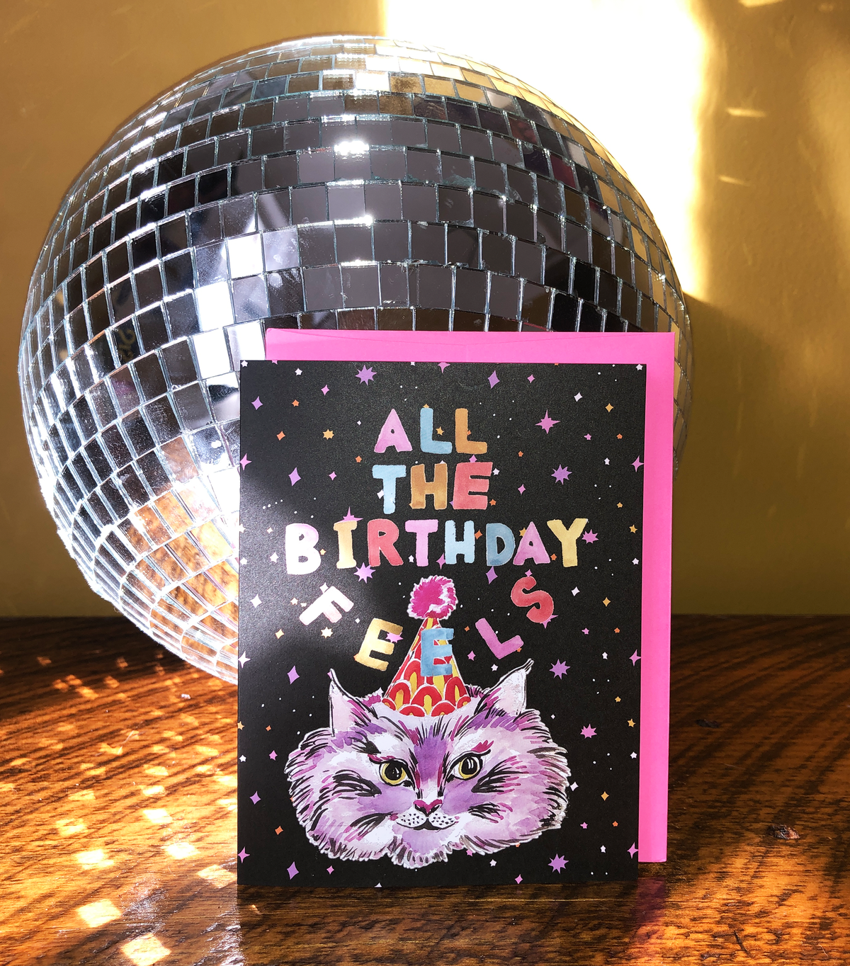 Card with cat illustration and 'All the Birthday Feels' text in front of a disco ball.