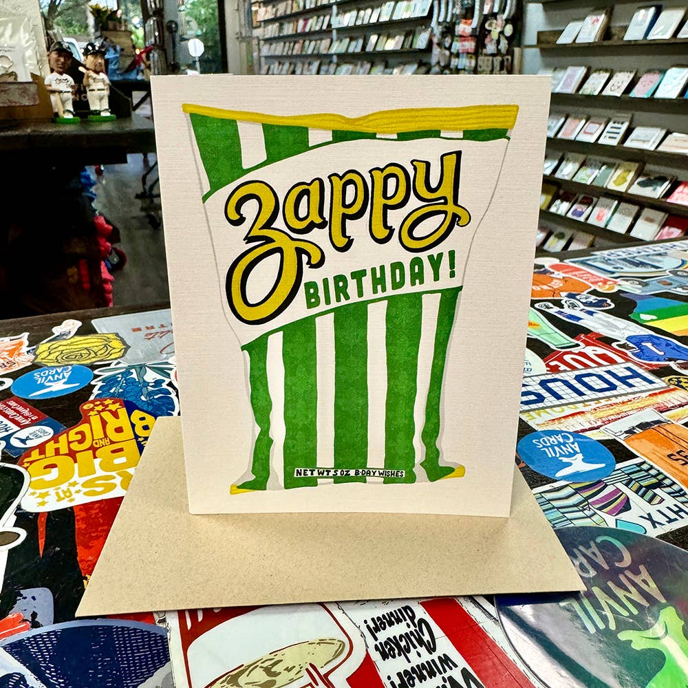 Zest up your birthday wishes with this Zappy Birthday greeting card! Made in Houston, Texas, this card features a bag of Zapp's Chips in the flavor Cajun Dill Gator-Tators with the phrase "Zappy Birthday!" Blank inside, perfect for adding your own unique touch. Created by real hands in Houston, Texas.