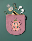 Secure your small valuables in the Amulet Halfmoon Pouch. Featuring a scarab beetle design on deep musky pink, perfect for keys, cards, and loose coins.