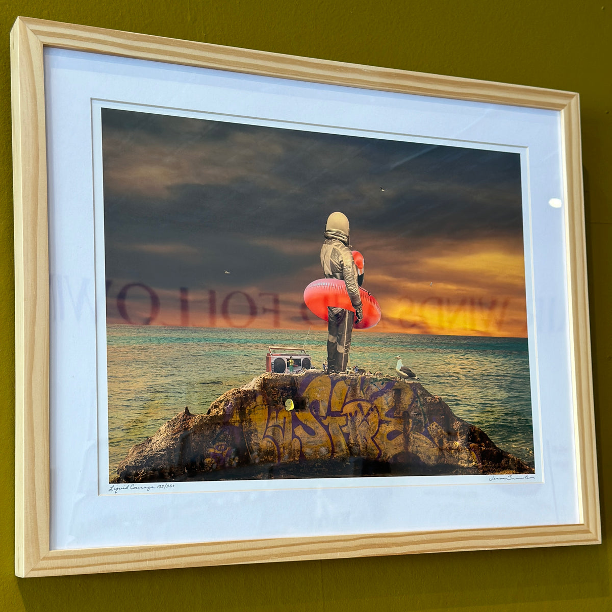 Liquid Courage art print in a light wood frame with a white mat on an olive green wall