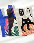 Cream, brown and blue knit cat shoulder bags lined up side by side