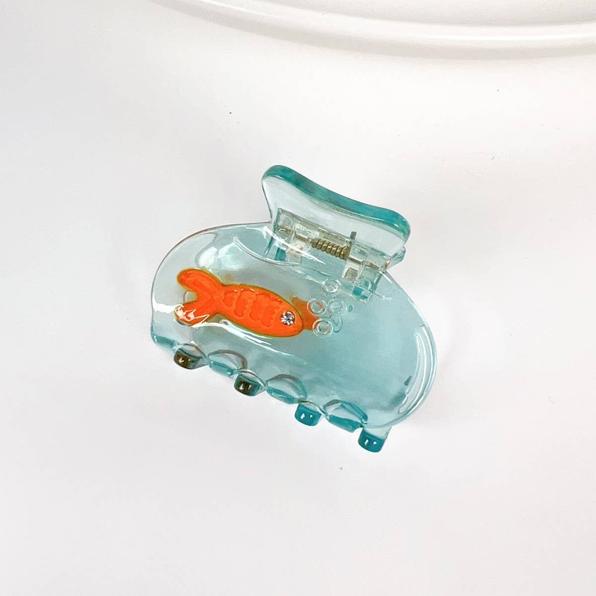 Add a little whimsy to your hairstyle with this mini koi fish claw clip. Made from smooth acetate with a sweet, sculptural silhouette, it brings a playful touch to half-ups, twists, and quick on-the-go styling. Lightweight, petite, and delightfully detailed, it’s an easy way to brighten your everyday look.