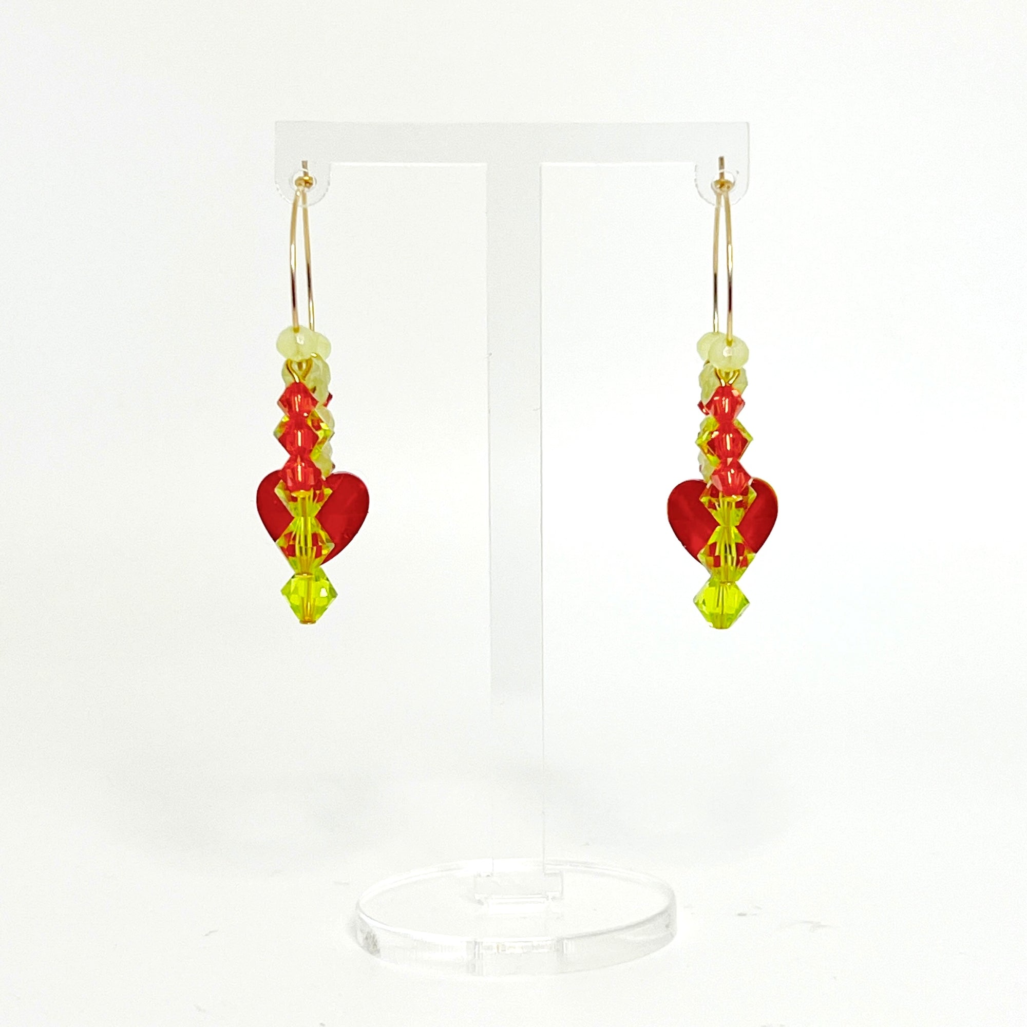 Joyful, flirty, and full of energy—these Small Spark Hoops are a burst of personality. A radiant heart-shaped crystal takes center stage, framed by watermelon and chartreuse tones that feel like summer bottled up. A scattering of dangling crystals adds playful movement, making these hoops perfect for anyone who loves to stand out and shine.