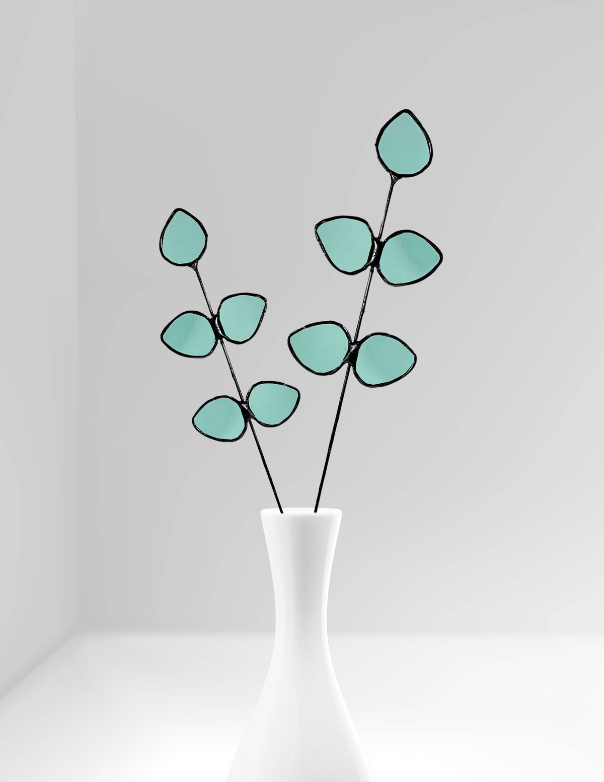 Bring a pop of color and artistry to your home with this handcrafted stained glass gumdrop eucalyptus stem by Samara Designs Studio. This stem is made from beautiful transparent seafoam green stained glass, cut and assembled by hand to create a lasting botanical accent that will never wilt or fade.