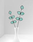 Bring a pop of color and artistry to your home with this handcrafted stained glass gumdrop eucalyptus stem by Samara Designs Studio. This stem is made from beautiful transparent seafoam green stained glass, cut and assembled by hand to create a lasting botanical accent that will never wilt or fade.