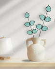 Bring a pop of color and artistry to your home with this handcrafted stained glass gumdrop eucalyptus stem by Samara Designs Studio. This stem is made from beautiful transparent seafoam green stained glass, cut and assembled by hand to create a lasting botanical accent that will never wilt or fade.