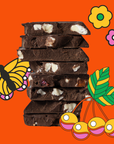 Stack of chocolate bars with white pieces on an orange background with decorative elements.