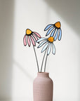 Stained glass coneflowers in pink, white and pale blue in a pink textured vase