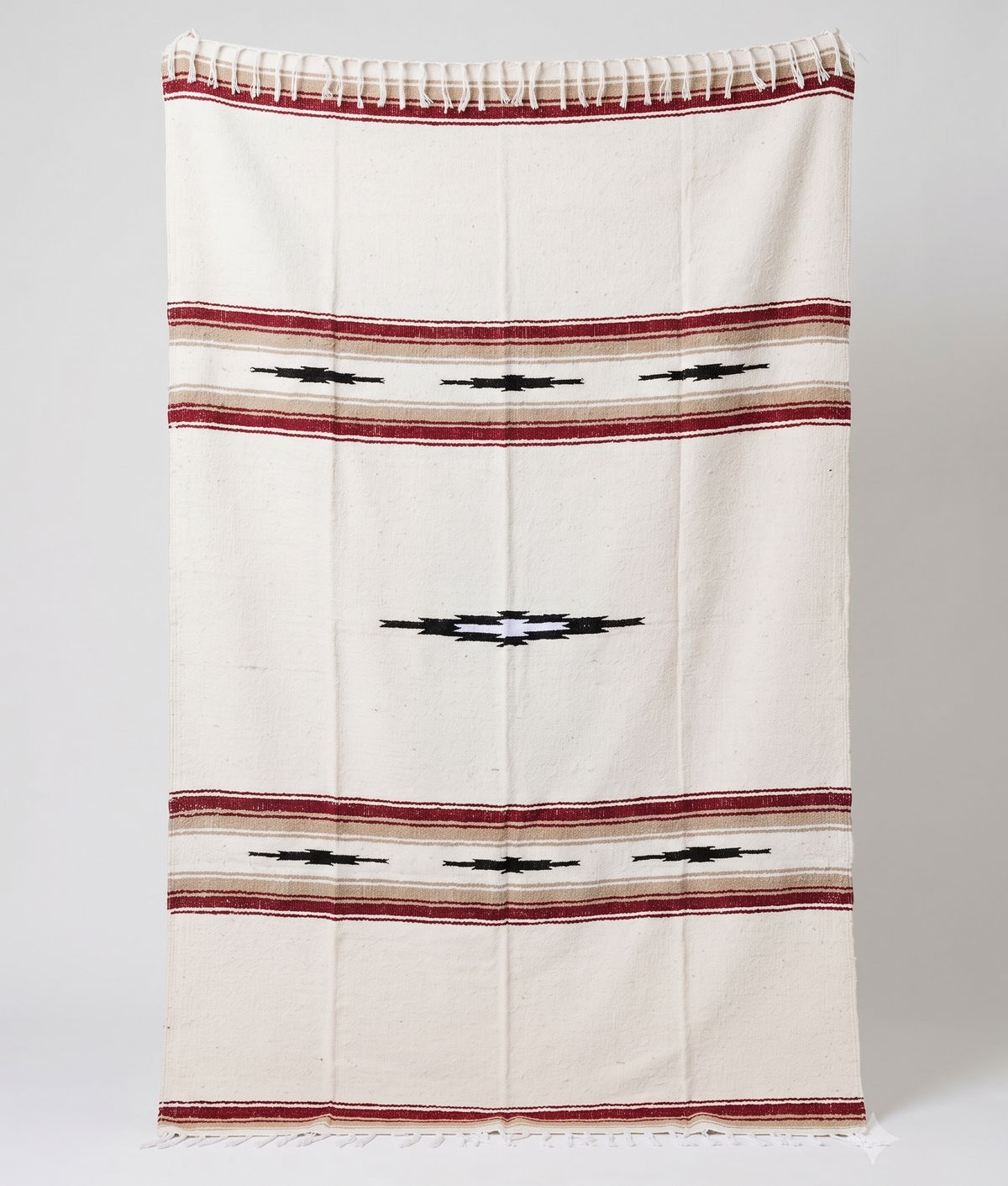 Cream Desert Mesa blanket with red and tan stripes and black diamond motifs, hanging flat