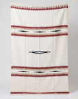 Cream Desert Mesa blanket with red and tan stripes and black diamond motifs, hanging flat