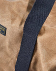 Close-up of the navy webbing strap and Readywares label on the duffel bag