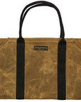 Empty tan waxed canvas firewood carrier with black webbing handles and a Readywares label