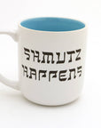 White mug with blue interior and 'Shmutz Happens' text on a white background