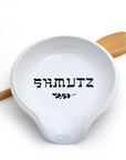 White ceramic dish with wooden handles and 'SHMUTZ' text on a white background
